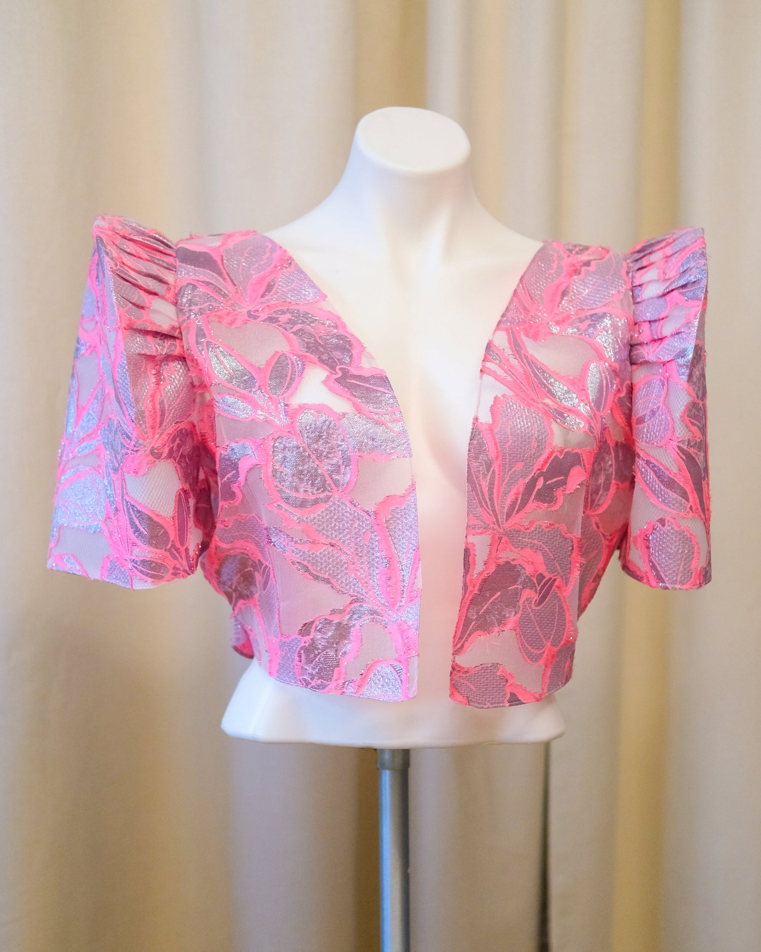 A cropped pink Rosal Filipiniana bolero blouse made from reverse jacquard fabric with a textured finish and bold terno butterfly sleeves.