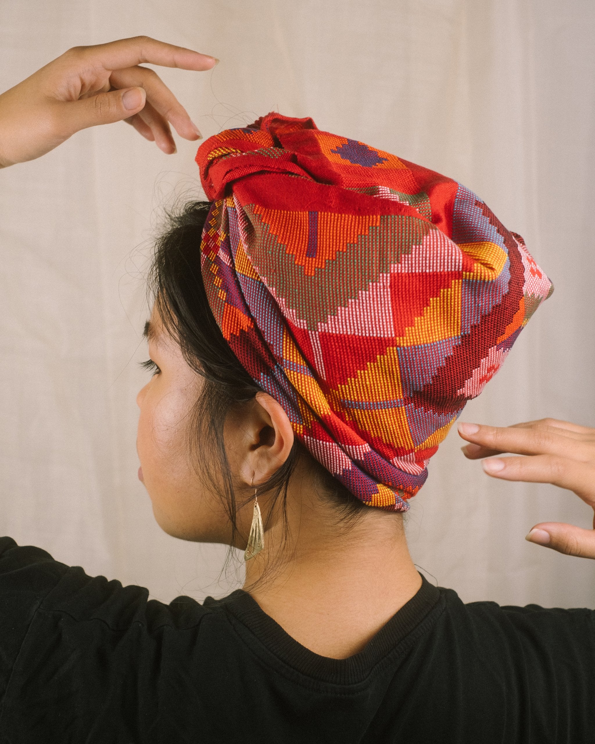 A vibrant, handwoven Yakan headscarf with geometric patterns in red, orange, yellow, purple, and pink hues. Yakan Headscarf Unisex Headscarf | Narra Studio