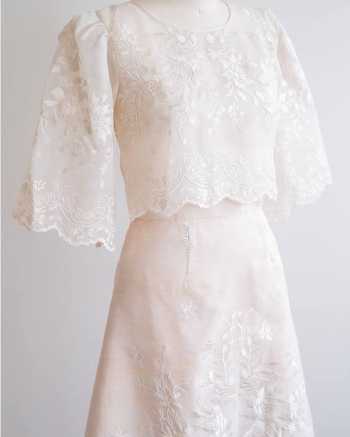 Filipiniana blouse and skirt set made of silk organza, featuring intricate rose floral embroidery and scalloped hems on the sleeves, blouse, and skirt.