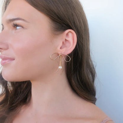 Lazo Threader Earrings with gold bow-shaped wire design and dangling pearl charm, handcrafted by Filipino artisans