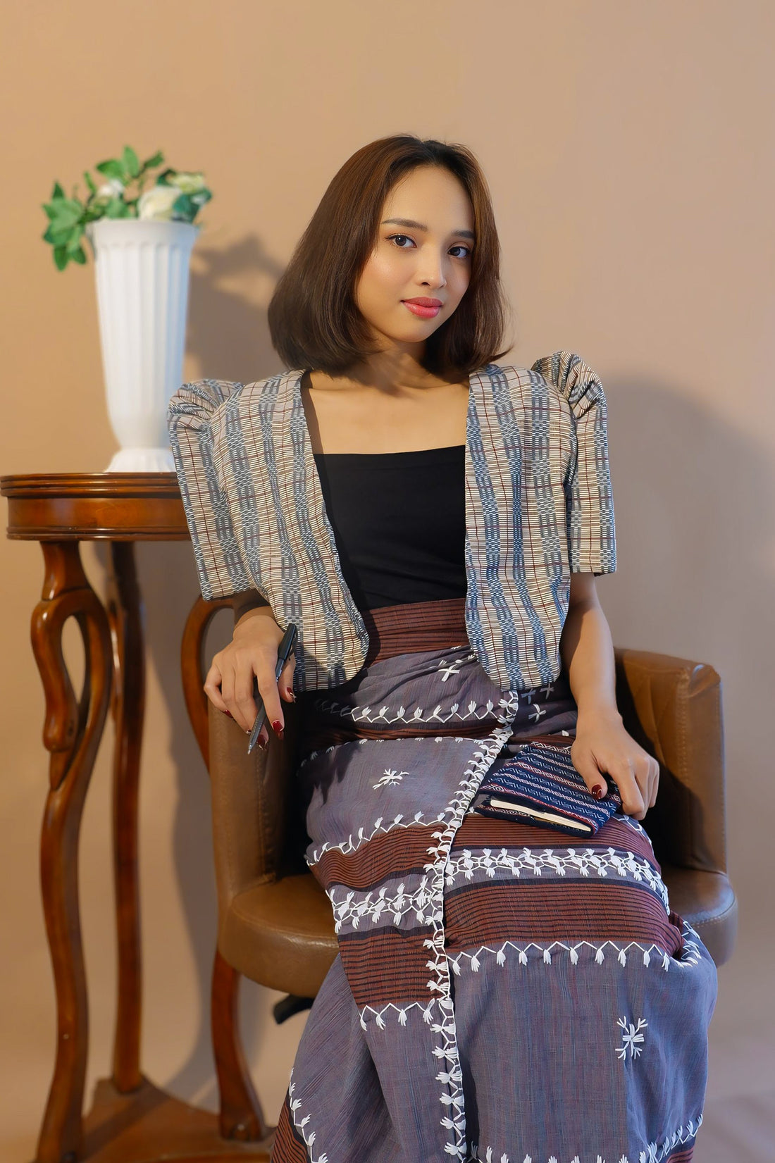 A woman wearing a mocha Binakol cropped bolero and a traditional Filipino skirt.