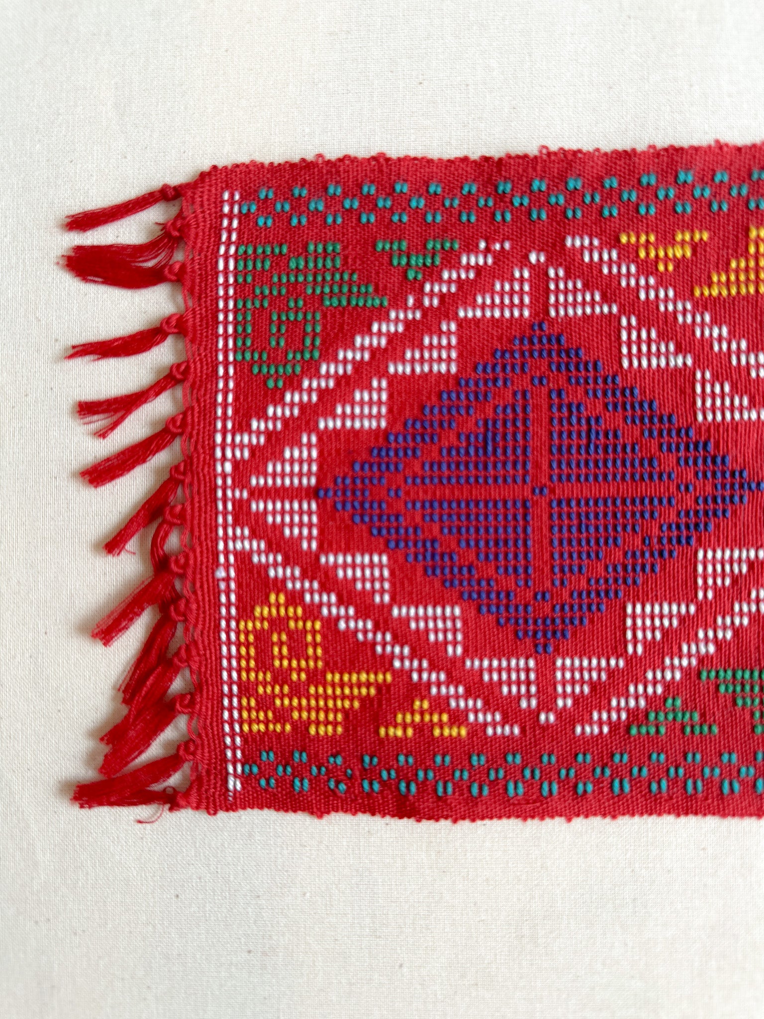 Yakan Handwoven Cloth - Red Coaster. A traditional Yakan handwoven square in Red with vibrant blue, yellow, and green geometric patterns. A stunning piece of Philippine heritage, perfect for display or functional décor.