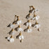 Delicate cascading Caida Bloom earrings with white fabric flowers and pearls, handcrafted by Filipino artisans.