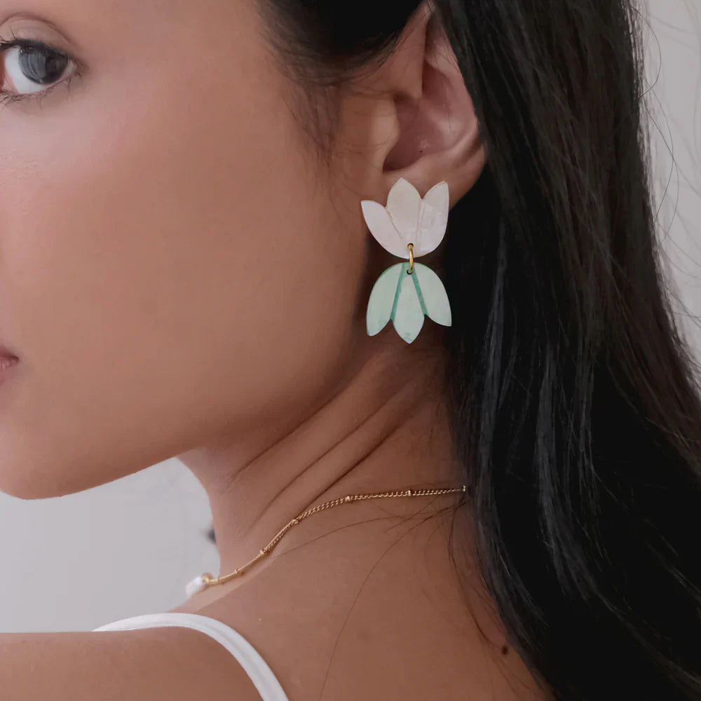 Guita Drop Women’s Earrings
Hand-carved floral earrings by Arete featuring layered petals in pearlescent and green tones.