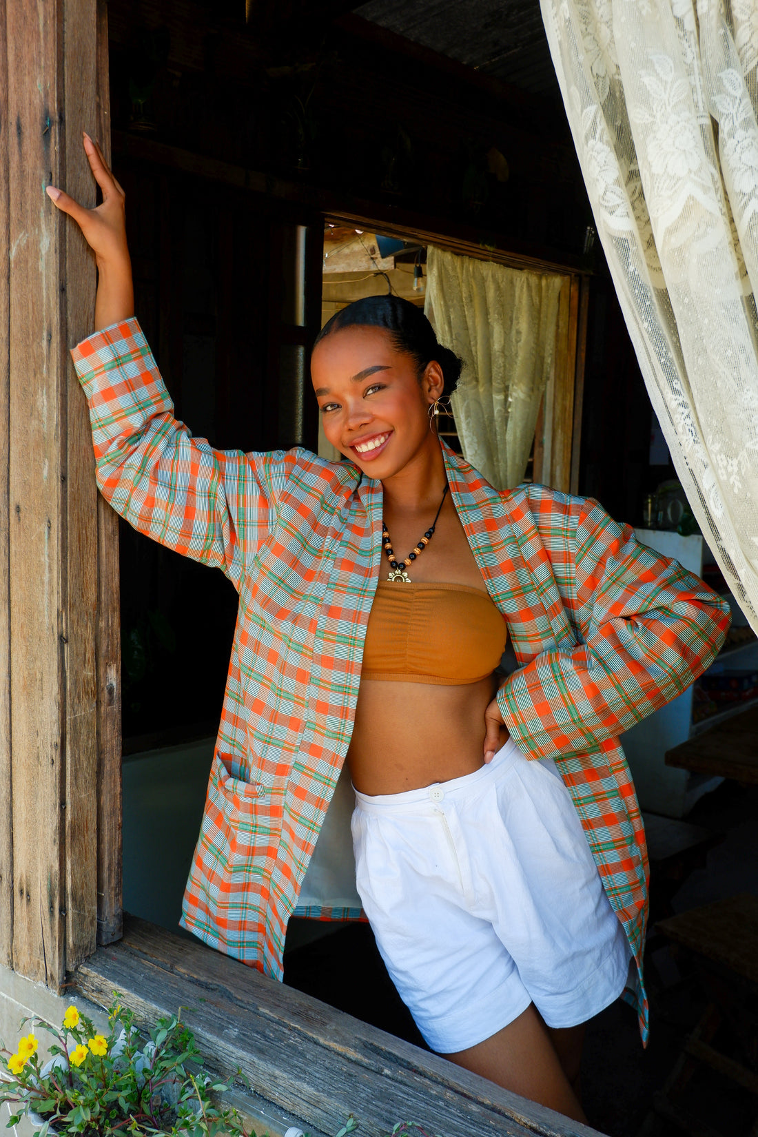 A green and orange Binakol jacket, a traditional Filipino handwoven textile, styled casually. Narra Studio