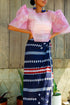 A traditional Filipino outfit featuring a handwoven navy tapis wrap skirt with intricate white and red embroidery in geometric patterns. 