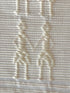 Handwoven Kibin Ilocos Placemat Set Placemat. A Handwoven Ilocos placemat with the "Kibin Kibin" pattern—figures holding hands in raised off-white motifs on fabric.