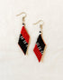 A pair of handwoven Kalinga earrings in a red and black trapezium design, featuring white and black bead accents, blending traditional Filipino craftsmanship with modern, artisan-made style.