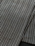 Handwoven sablay sash featuring horizontal patterns in black and white. The intricate geometric designs include X and diamond motifs, arranged in alternating bands that reflect traditional Filipino textile artistry.