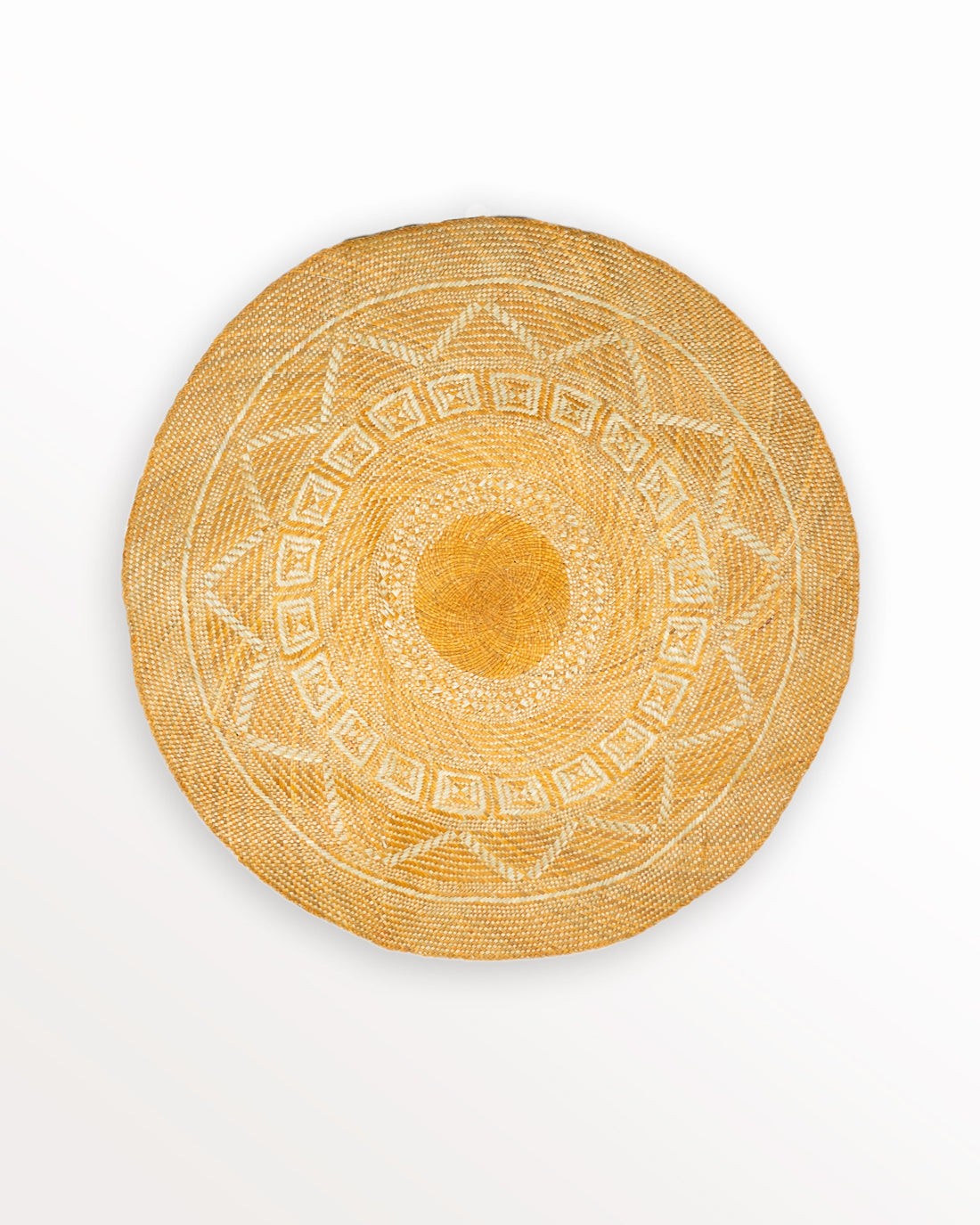 Sunrise Banig Mat. A round woven banig mat in plant-dyed and natural colored woven grass, with intricate sunburst and diamond-shaped geometric patterns.  Handwoven decorative textile from the Philippines.