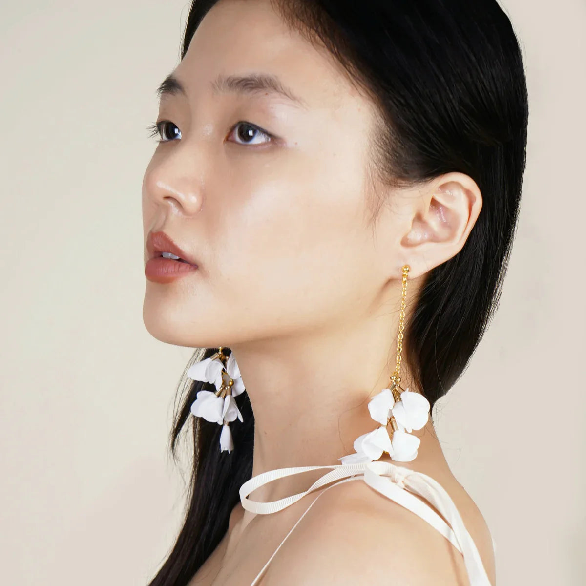 White handcrafted Bloom Drop earrings with layered fabric petals, made in the Philippines—an elegant expression of Filipino artistry and design.
