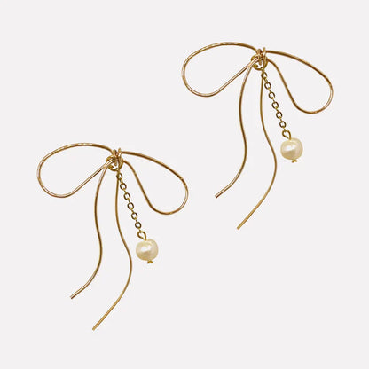 Lazo Threader Earrings with gold bow-shaped wire design and dangling pearl charm, handcrafted by Filipino artisans