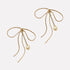 Lazo Threader Earrings with gold bow-shaped wire design and dangling pearl charm, handcrafted by Filipino artisans